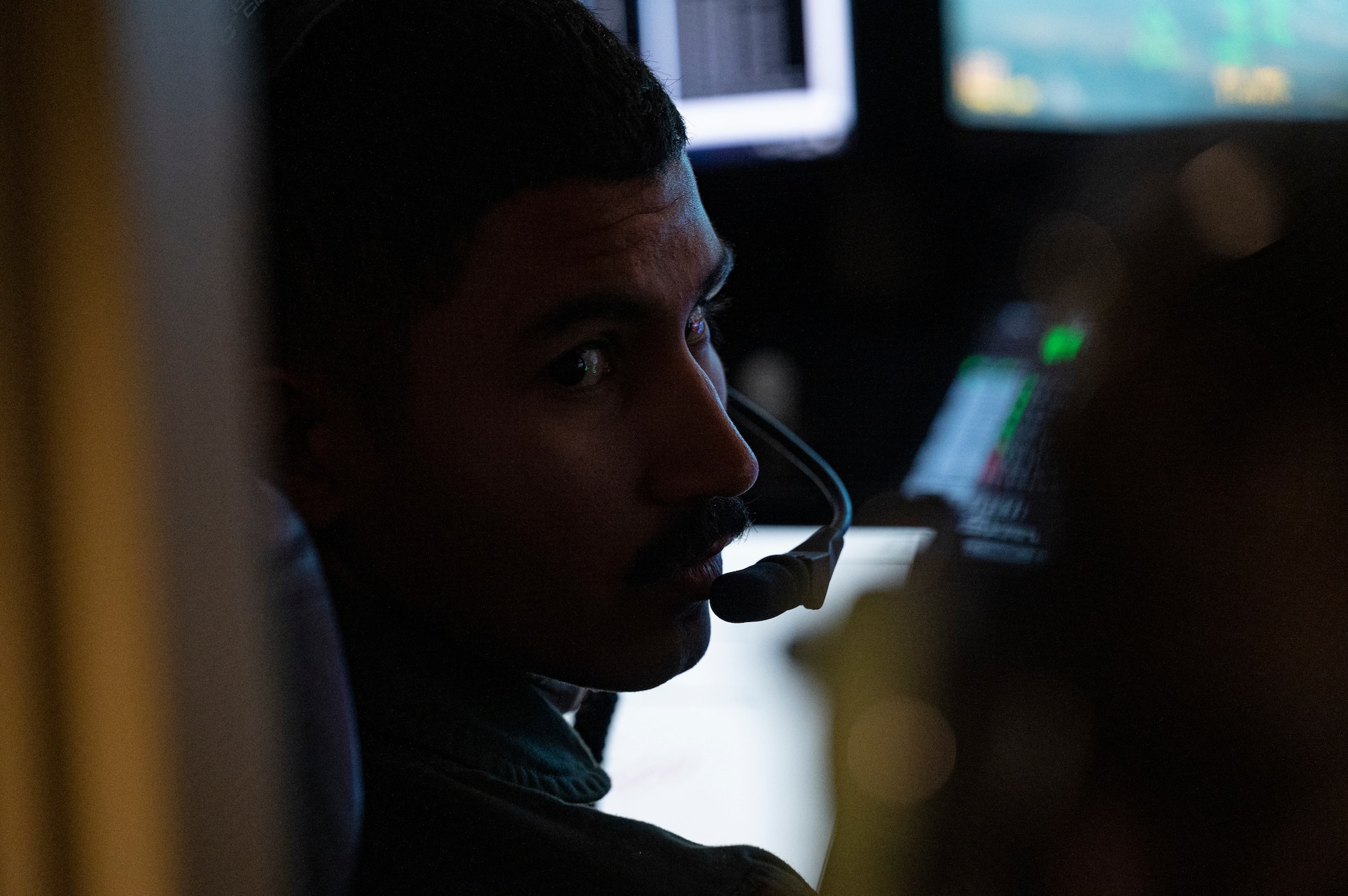 U.S. Air Force 2nd Lt. Cristino Garcia, 6th Attack Squadron MQ-9 Reaper student pilot communicates with an instructor pilot during a training flight in a ground control station, Holloman Air Force Base, New Mexico, Oct. 13, 2022. Student pilots at the 6th ATKS utilize these training scenarios to practice hands-on learning and demonstrate their skill proficiency when piloting an MQ-9.  (U.S. Air Force photo by Airman 1st Class Isaiah Pedrazzini)
