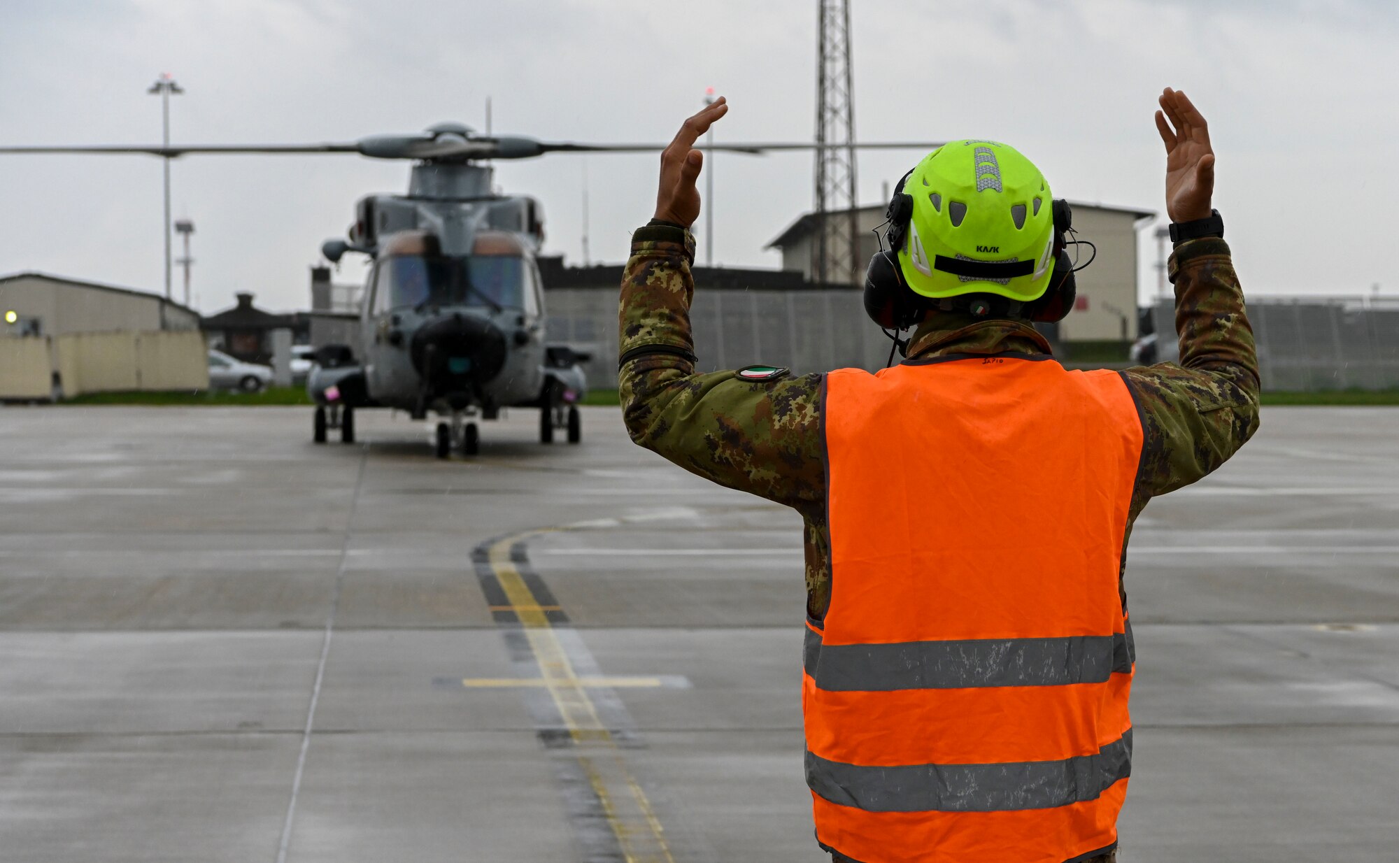 Italian Air Force Maintainer marshaling in a helicopter as it lands at Spangdhalem.