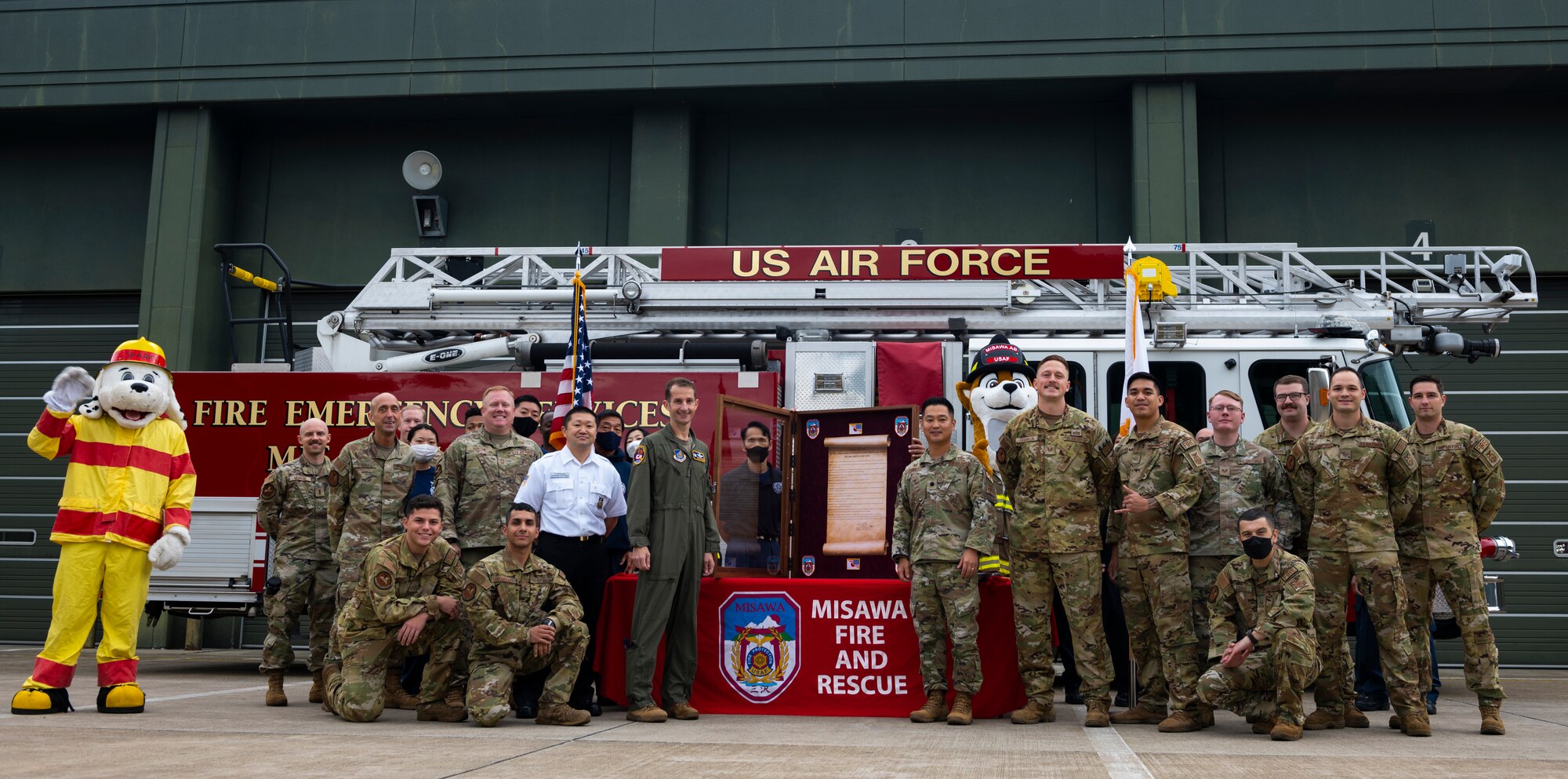 Group of Airmen pose for a group photo in front of a fire truck.