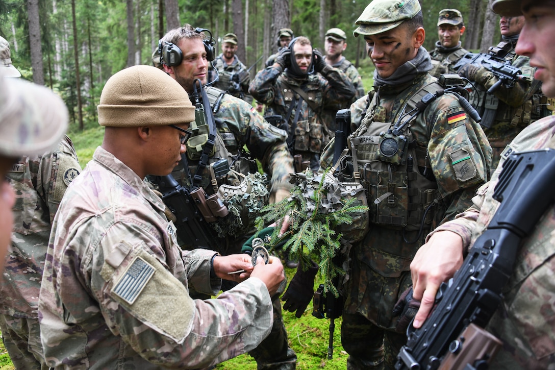 A U.S. service member exchanges patches with a German service member.