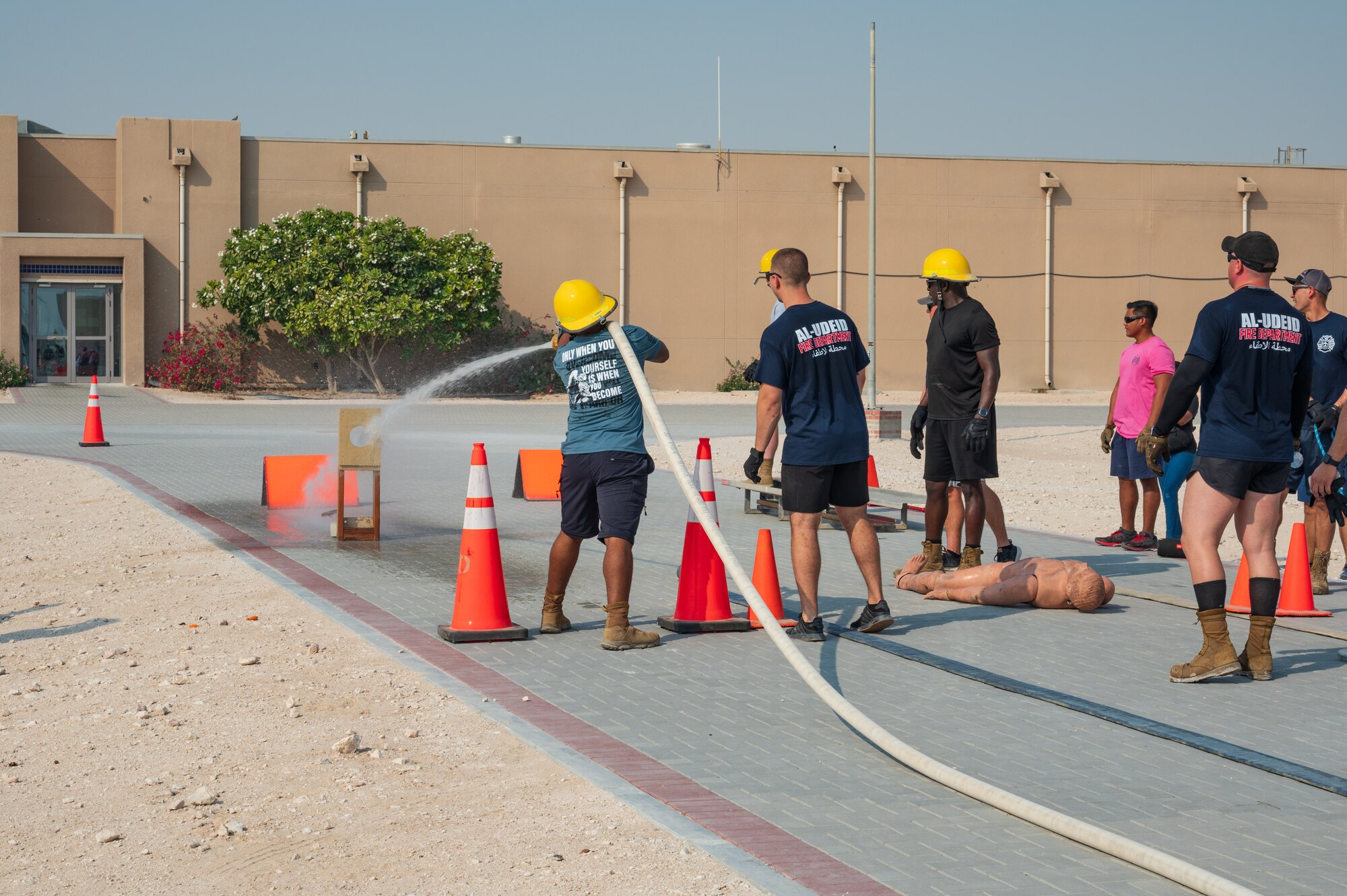 U.S. Air Force firefighters assigned to the 379th Expeditionary Civil Engineering Squadron spray water on a target in the fire rodeo exercise Oct 15, 2022 at Al Udeid Air Base, Qatar. During fire safety week the firefighters conducted the fire rodeo where they hosted an open competition featuring elements of physical prowess needed to perform the lifesaving skills associated with their job. (U.S. Air Force photo by Staff Sgt. Dana Tourtellotte)