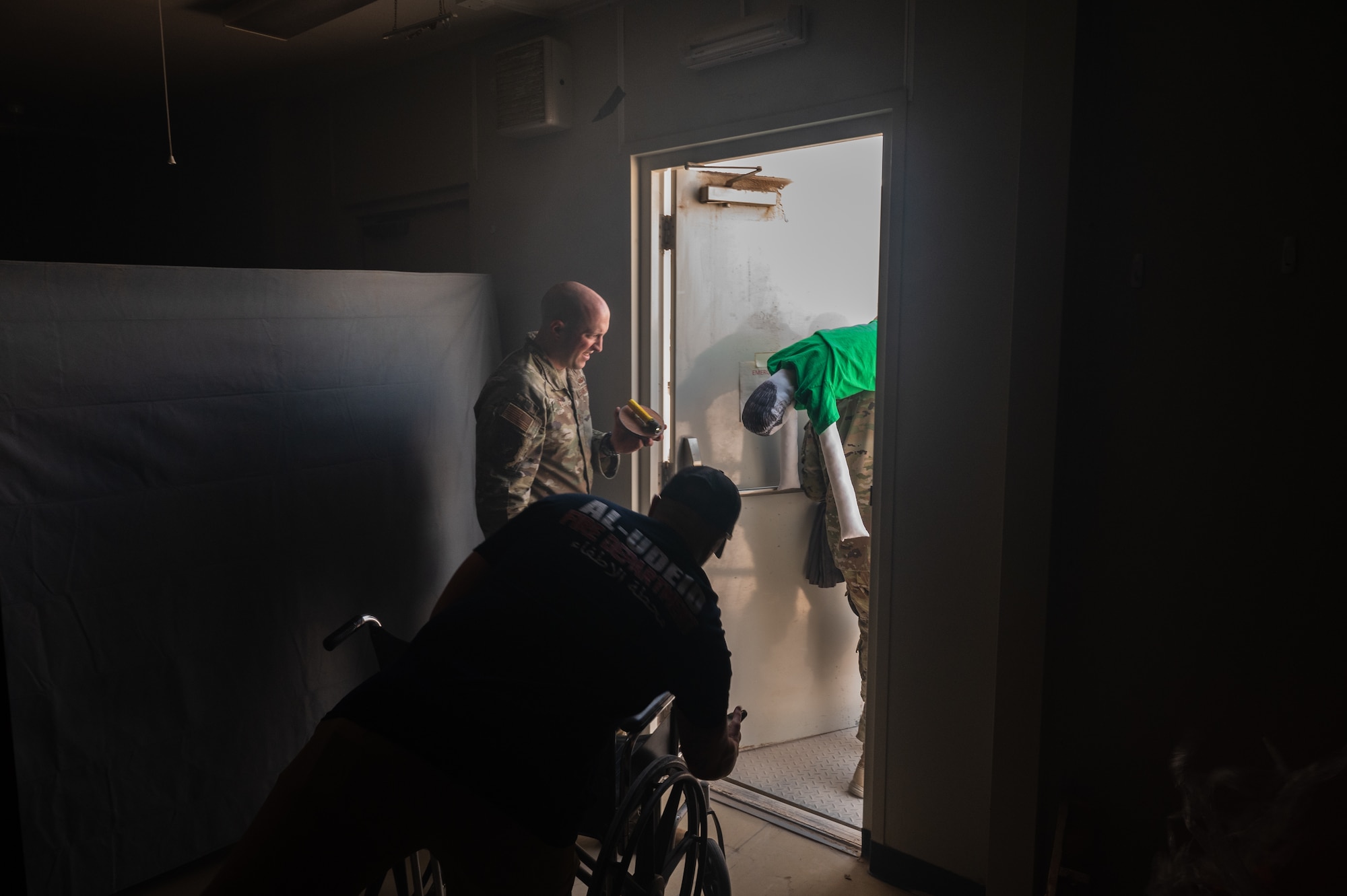 U.S. Air Force Maj Jacob S. Flatz, 379th Expeditionary Civil Engineer Squadron deputy commander, ensures accountability of all individuals before exiting the fire escape room during fire safety awareness exercise Oct. 12, 2022 at Al Udeid Air Base, Qatar. Flatz ensured the simulated victim made it out of the building safely and quickly as part of the simulation.