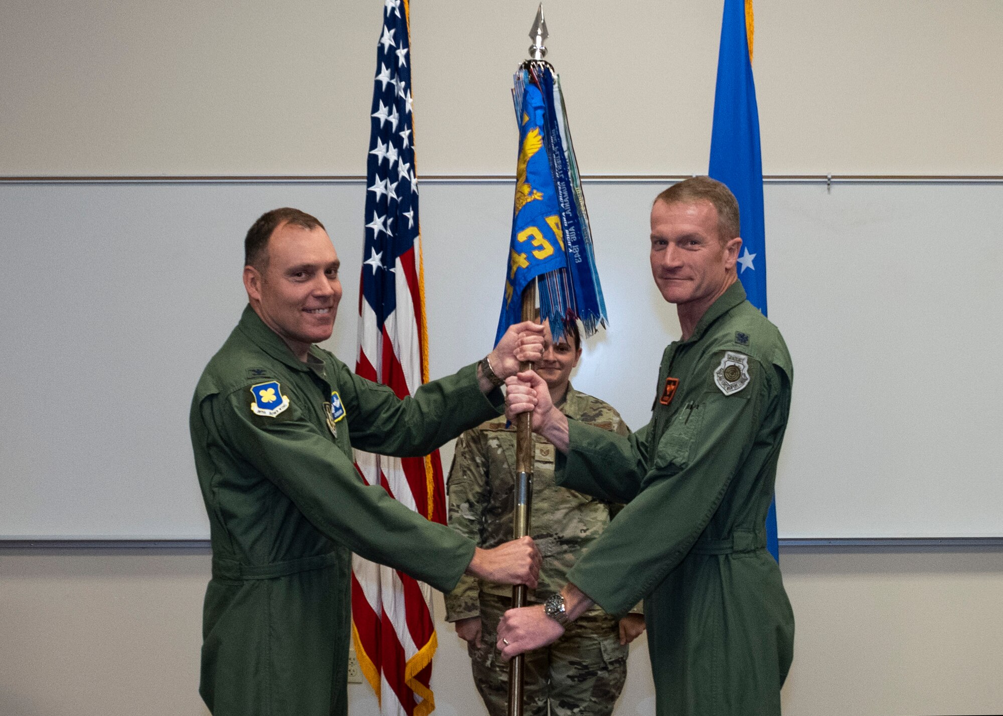 Photo of two Airmen exchanging guidon