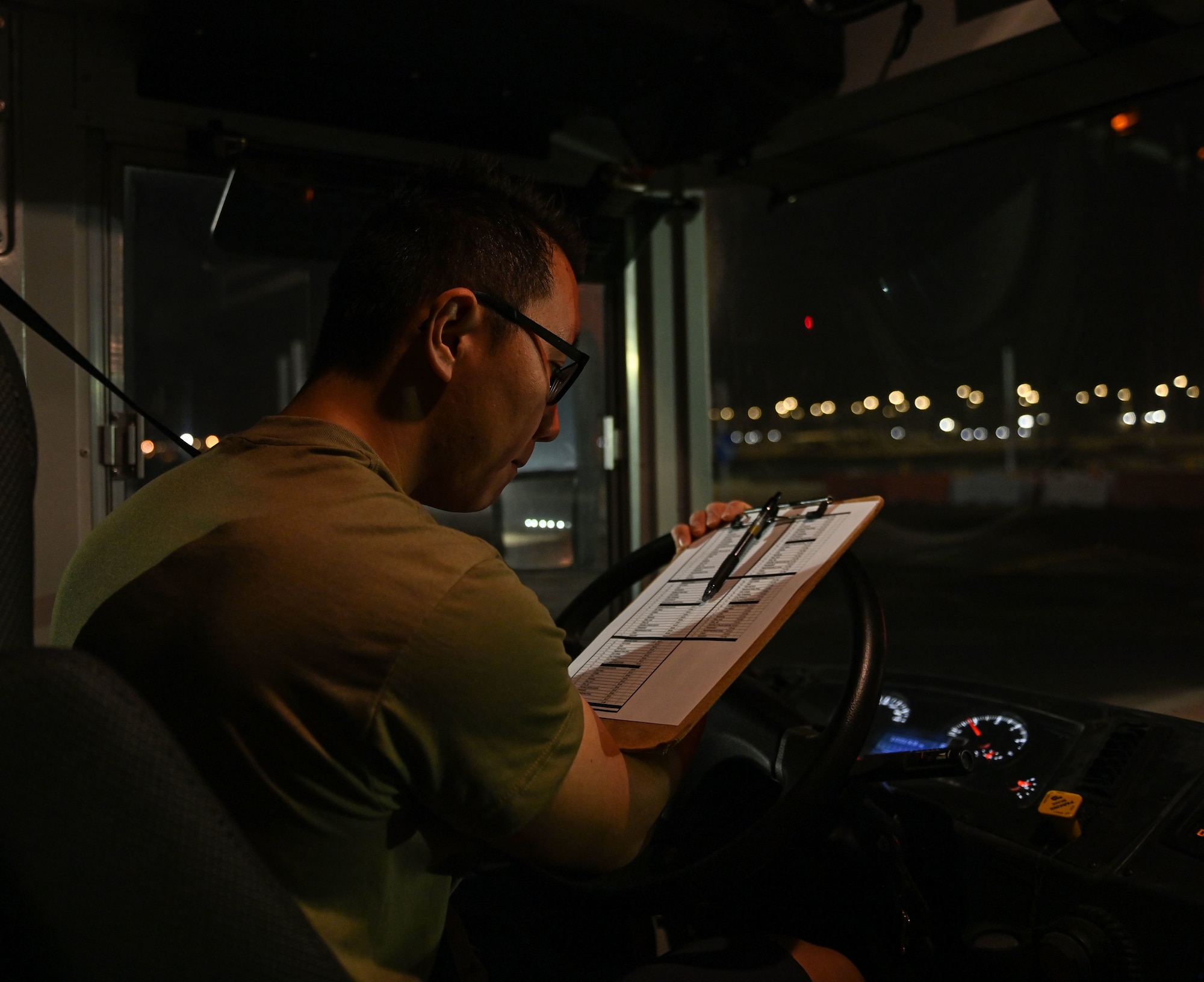 U.S. Air Force Senior Airman Tongil Lee, 379th Expeditionary Logistics Readiness Squadron ground transportation, checks his route log to ensure his shuttle is on schedule Oct. 3, 2022 at Al Udeid Air Base, Qatar. The base shuttle system makes 400 stops a day and helps AUAB members get to their destination. (U.S. Air National Guard photo by Master Sgt. Michael J. Kelly)