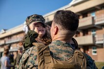 A young girl puts on her dad's cover during a homecoming for Battalion Landing Team 2/6, 22nd Marine Expeditionary Unit (MEU), aboard Camp Lejeune, North Carolina, Oct. 10, 2022. Marines and Sailors assigned to the 22nd MEU returned home after completing a seven-month deployment with the Kearsarge Amphibious Ready Group in the U.S. Naval Sixth Fleet area of operations. (U.S. Marine Corps photo by Cpl. Yvonna Guyette)