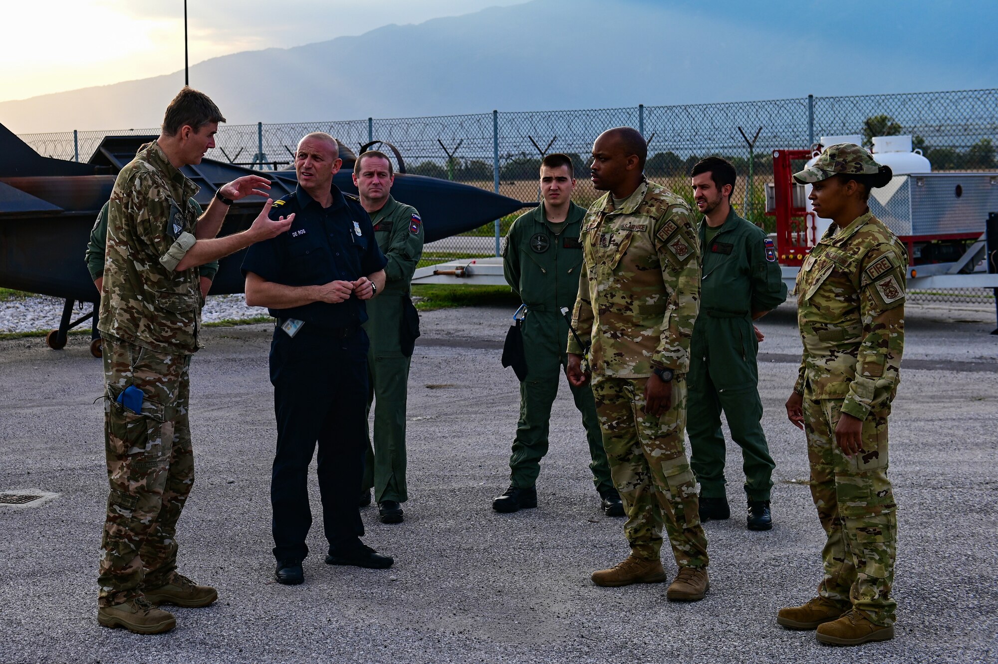 Slovenian Air Force and Italian firefighters speak with U.S. Air Force Master Sgt. Timothy Sherrod, 31st Civil Engineer Squadron assistant chief of fire prevention, about different procedures and training at Aviano Air Base, Italy, Oct. 12, 2022. The discussion was held prior to a live fire training demonstration to showcase our capabilities. (U.S. Air Force photo by Senior Airman Thomas S. Keisler IV)
