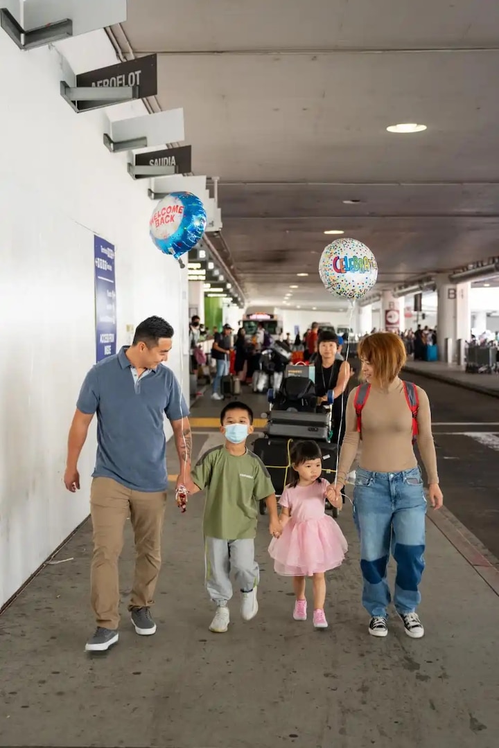 Coast Guard family walks together after being reunited at Los Angeles International Airport, September 13, 2022. The family had not been together since December of 2019 when China first went into lock and prevented the son from returning home. (U.S. Coast Guard photo by Petty Officer 3rd Class Aidan Cooney)