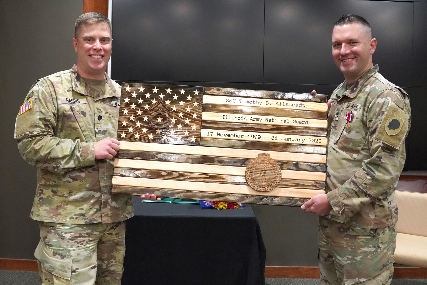 Lt. Col. Joseph Harris, the Recruiting and Retention Battalion commander, presents a wooden flag to Sgt. First Class Timothy Allsteadt, of Bourbonnais, Illinois, during his retirement ceremony at Camp Lincoln in Springfield, Illinois, October 13.