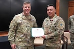 Lt. Col. Joseph Harris, the Recruiting and Retention Battalion commander, presents a Meritorious Service Medal to Sgt. 1st Class Justin Wolfe, of Sycamore, Illinois, during his retirement ceremony at Camp Lincoln in Springfield, Illinois, October 13.