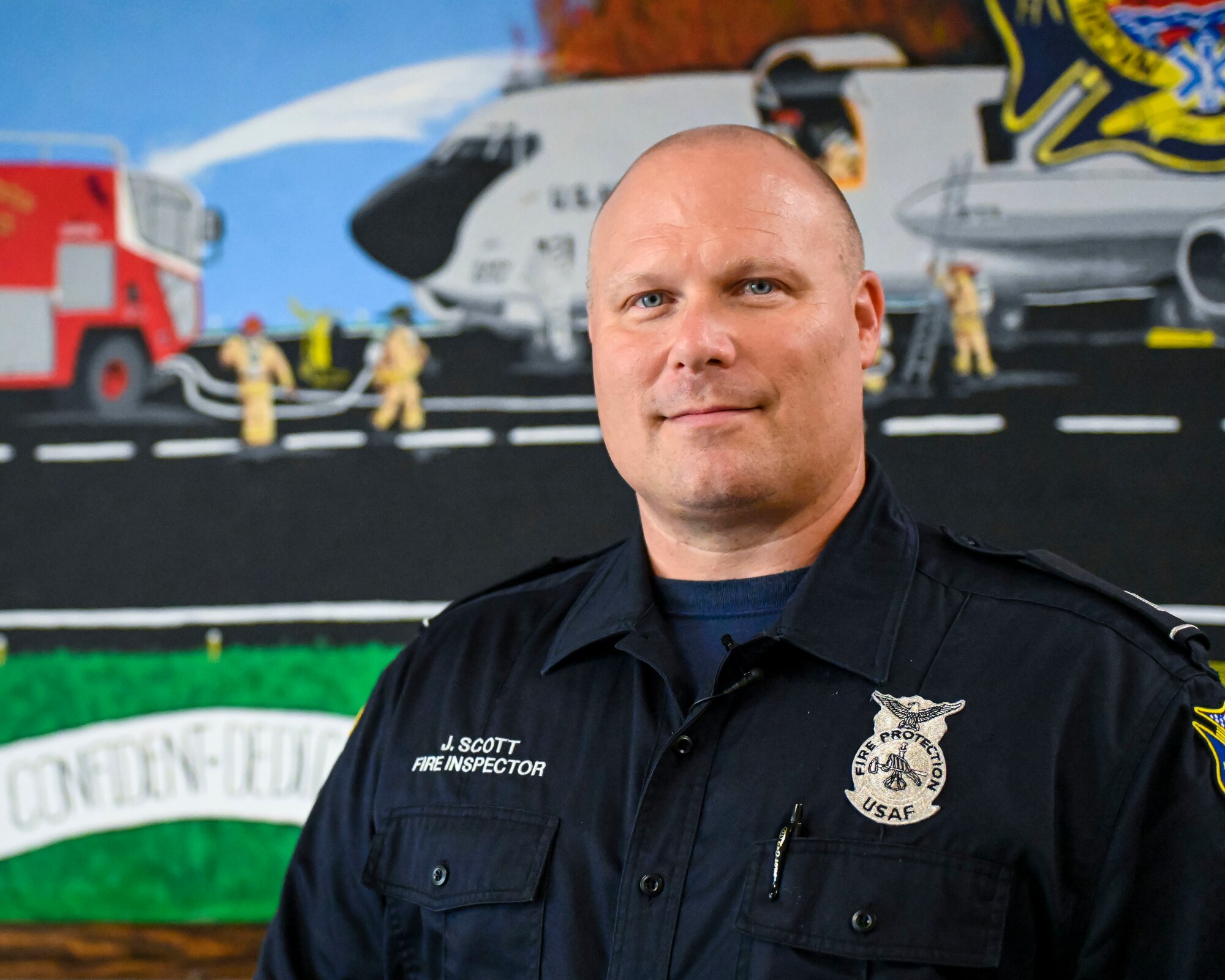 Jay Scott, a fire inspector assigned to the 6th Civil engineering Squadron poses with a mural he painted at MacDill Air Force Base, Florida, Oct. 13, 2022. The mural depicts firefighters responding to a KC-135 Stratotanker fire on a flightline. Recently, Scott completed two large-scale murals at Fire Station 1 along with a number of detailed sketches he has gifted to coworkers. (U.S. Air Force photo by Airman 1st Class Lauren Cobin)