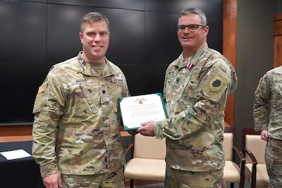 Lt. Col. Joseph Harris, the Recruiting and Retention Battalion commander, presents a Meritorious Service Medal to Sgt. 1st Class David Keefer, of Charleston, Illinois, during his retirement ceremony at Camp Lincoln in Springfield, Illinois, October 13.