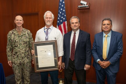 Brian Savidge receives an award for his 40 years of government service during the Naval Surface Warfare Center, Philadelphia Division Fiscal Year (FY) 2022 3rd Quarter Awards Ceremony on Aug. 1, 2022. Pictured from left to right: NSWCPD Commanding Officer Capt. Dana Simon; Mechanical Engineer, Brian Savidge; NSWCPD Technical Director (acting) Chris Savage; NSWCPD Quality Management Officer Director Frank Gerace. (U.S. Navy photo by Spc. Jermaine Sullivan/Released)