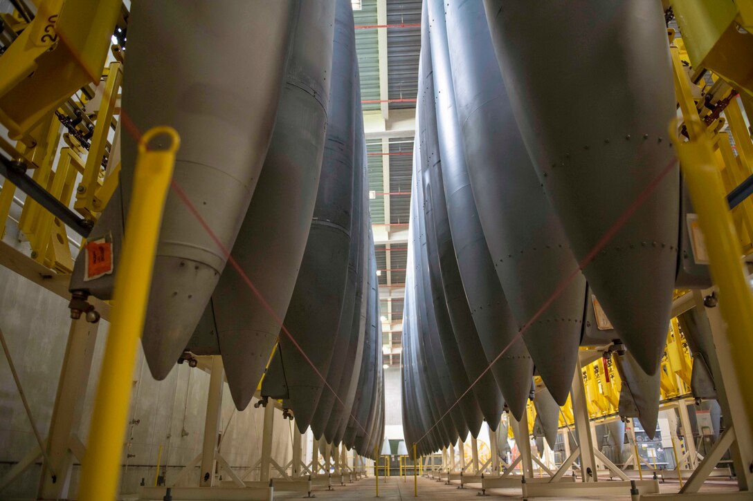 Fuel tanks sit vertically in formation in a large warehouse.