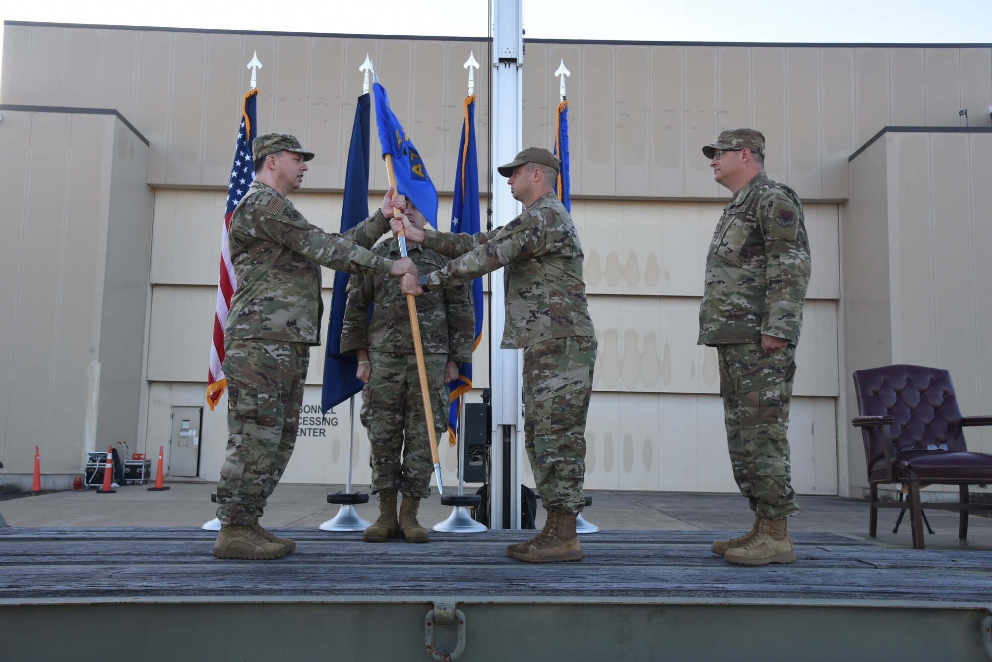 A man in an Air Force uniform hands over a flag.