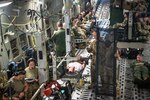 airmen set up a configuration for an aeromedical evacuation training flight on a C-17 Globemaster III