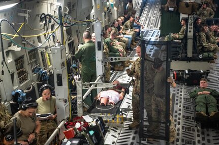 airmen set up a configuration for an aeromedical evacuation training flight on a C-17 Globemaster III