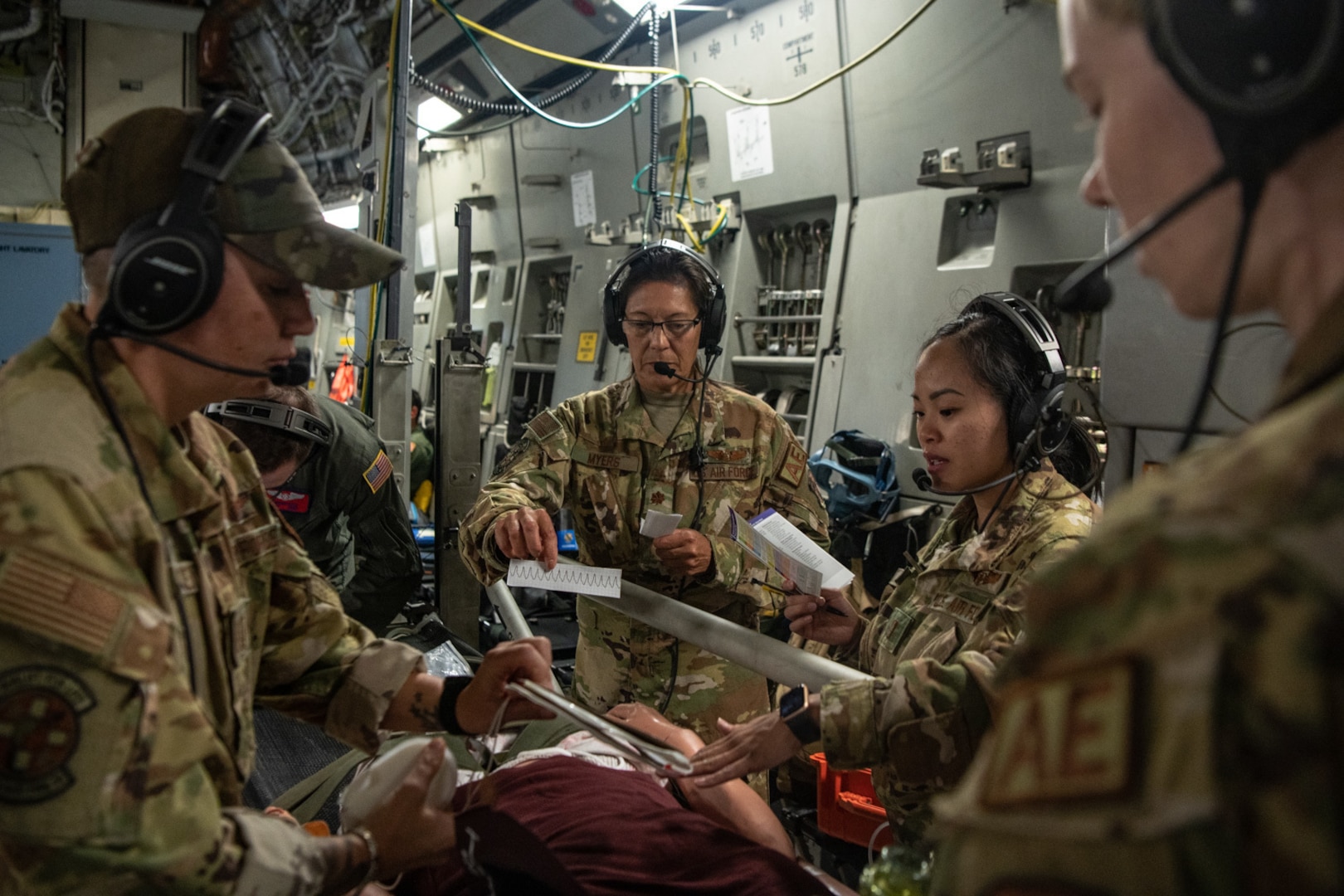 person holds heart monitor reading for simulated patient during medical training scenario