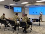 Cybersecurity officers from the Azerbaijan army listen to a presentation by an Oklahoma Air National Guard member during a cybersecurity knowledge exchange hosted by the Oklahoma National Guard at the Will Rogers Air National Guard Base in Oklahoma City. The Oklahoma National Guard hosted a multiday exchange focused on building cooperation between the two partners.