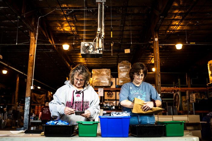 Air Force Marathon volunteers pack participation merchandise for virtual marathoners.