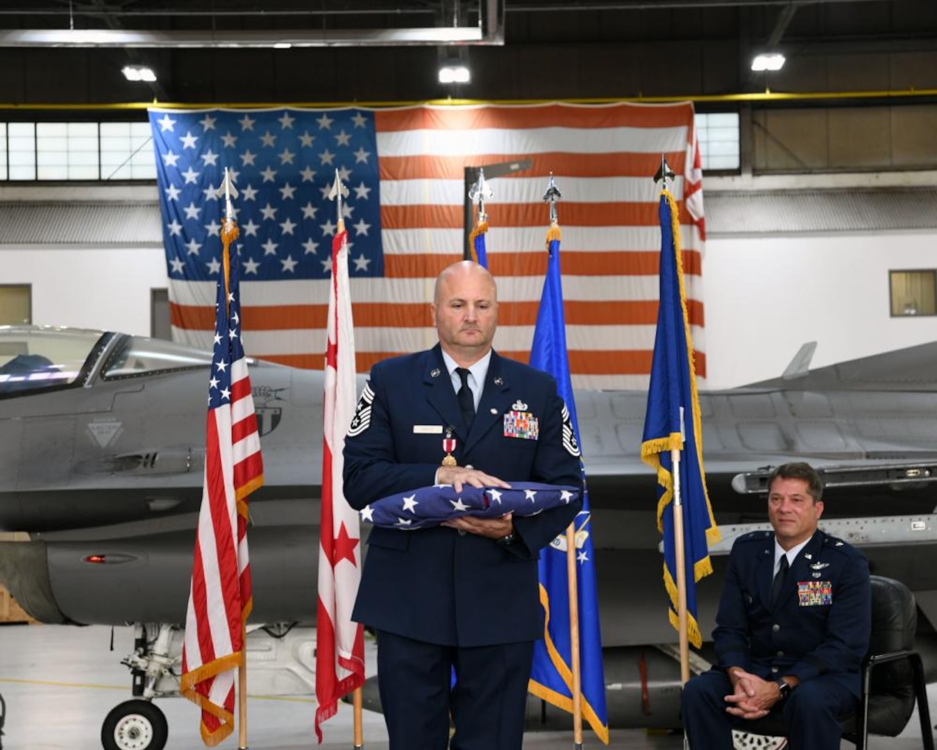 Chief Master Sgt. Charles C. Gass Jr., state command chief, D.C. National Guard, holds a flag at Joint Base Andrews Air Base, Maryland, Oct. 16, 2022. Gass was ceremoniously retired nearly 30 years of military service. (U.S. Air National Guard photo by Staff Sgt. Anthony Lee Small)