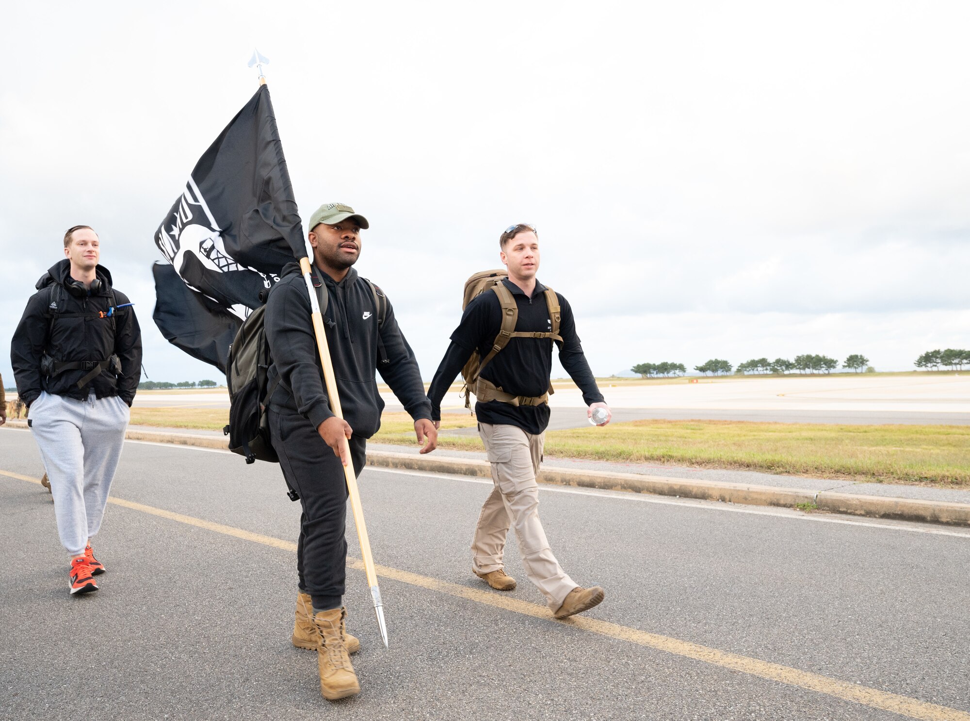 Staff Sgt. Gerald Jean-Pierre, 8th Comptroller Squadron financial analyst, carries a Prisoner of War and Missing in Action flag during an event at Kunsan Air Base, Republic of Korea, Oct. 7, 2022. Opening remarks were given by Col. Henry R. Jeffress, 8th Fighter Wing commander, who reminded service members the cost of those who served and became prisoners of war and for those who are still missing. (U.S. Air Force photo by Staff Sgt. Sadie Colbert)