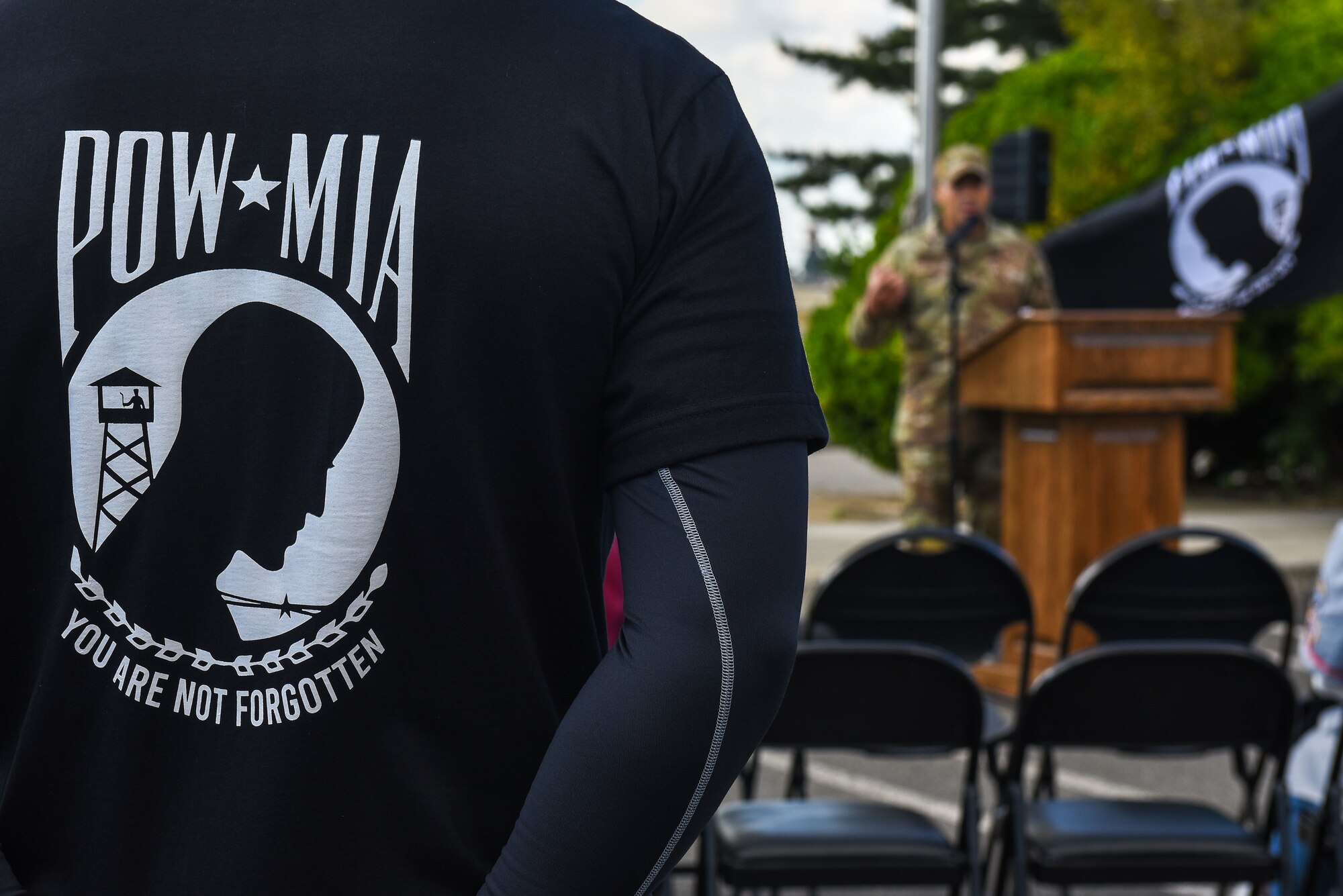 An Airman wears a Prisoner of War and Missing in Action shirt during a POW/MIA ceremony at Kunsan Air Base, Republic of Korea, Oct. 7, 2022. With more than 81,000 servicemembers unaccounted for, the U.S. military’s Defense POW/MIA Accounting Agency aims to recover all remains of each servicemember from past and present conflicts. (U.S. Air Force photo by Tech. Sgt. Timothy Dischinat)