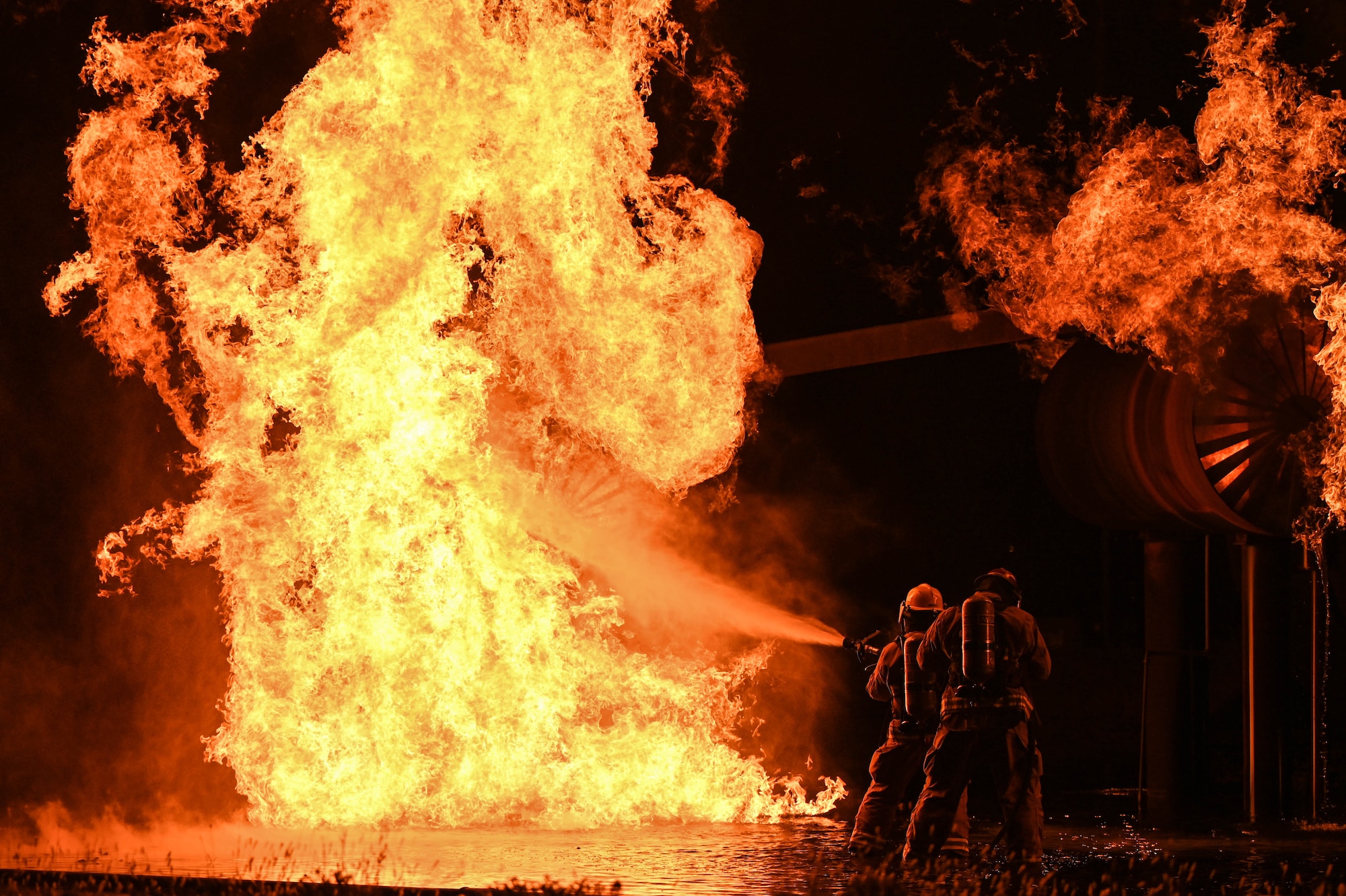 U.S. Air Force Chief Master Sgt. Sue Thompson, 97th Mission Support Group senior enlisted leader, and a firefighter from the 97th Civil Engineer Squadron, put out a fire during a live-burn training at Altus Air Force Base, Oklahoma, Oct. 12, 2022. At the fire department training grounds, there is a small model of an aircraft which is used for live-burn training. (U.S. Air Force photo by Senior Airman Kayla Christenson)