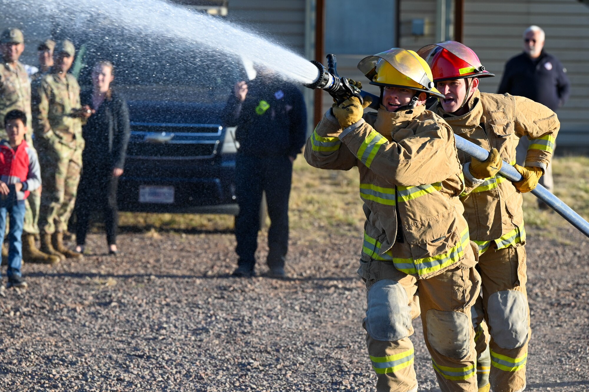 From left, U.S. Air Force Master Sgt. Nicholas Tester, 97th Training Squadron (TRS) first sergeant, and Lt. Col. Benjamin Davidson, 97th TRS commander, participate in a challenge as part of Fire Prevention Week at Altus Air Force Base, Oklahoma, Oct. 13, 2022. The challenge gives an opportunity for squadron commanders and first sergeants to experience what a firefighter does. (U.S. Air Force photo by Senior Airman Kayla Christenson)