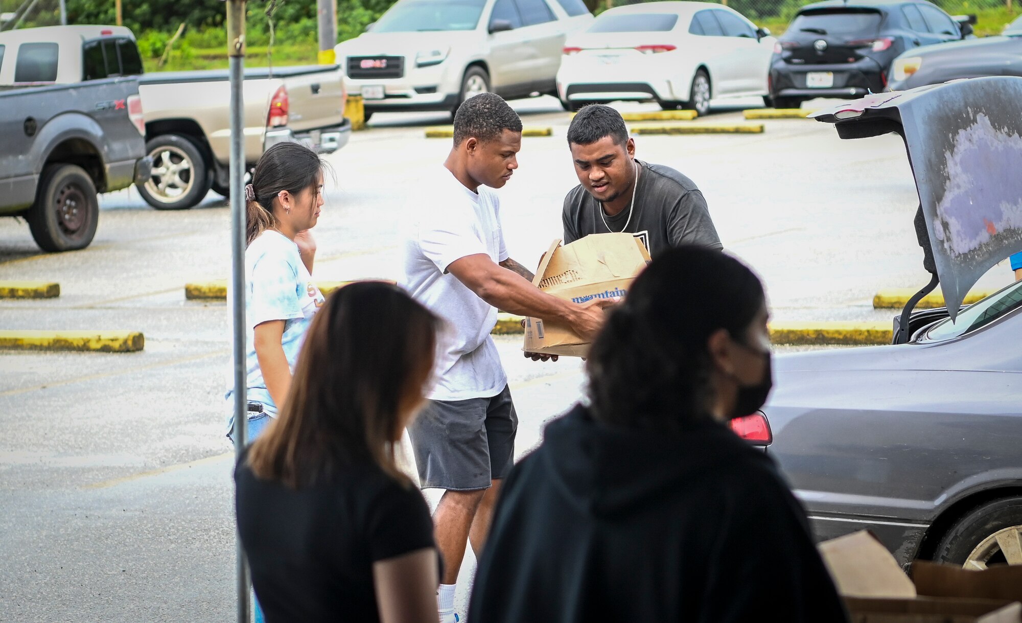 Airmen from the 36th Munitions Squadron volunteer during a food distribution line at the Yigo Gymnasium in Yigo, Guam, Oct. 14, 2022.