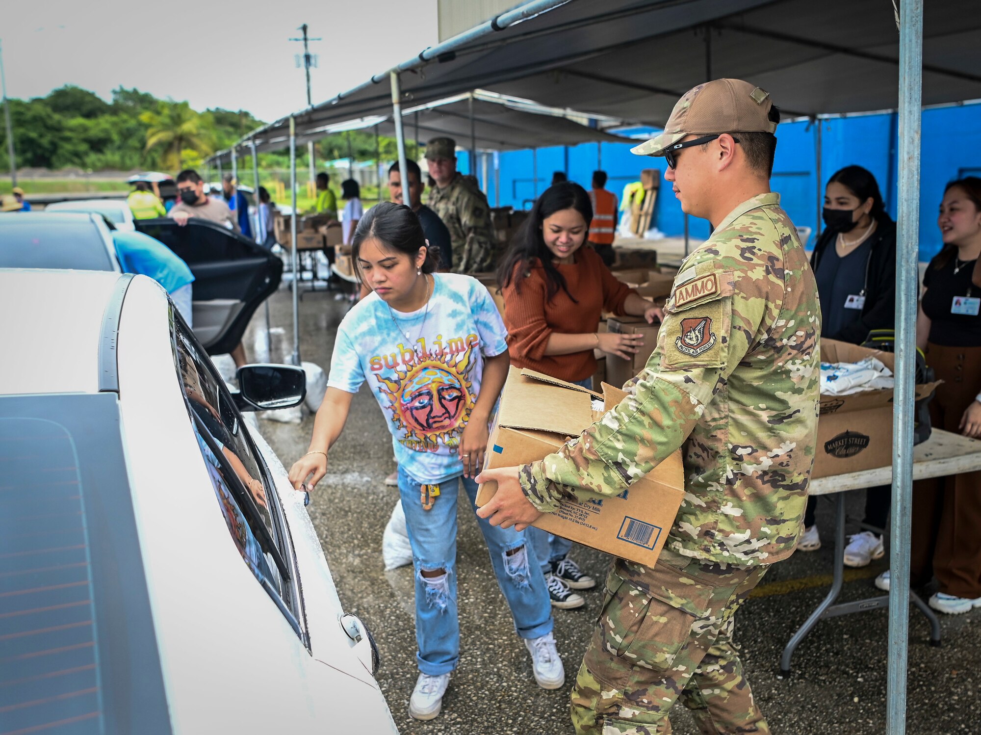 Airmen from the 36th Munitions Squadron volunteer during a food distribution line at the Yigo Gymnasium in Yigo, Guam, Oct. 14, 2022.