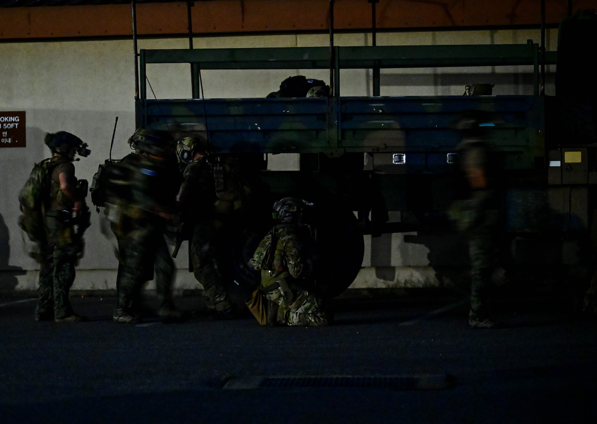 Several operators taking part in a combined U.S. and Republic of Korea (ROK) special operations forces training, stack up alongside a vehicle