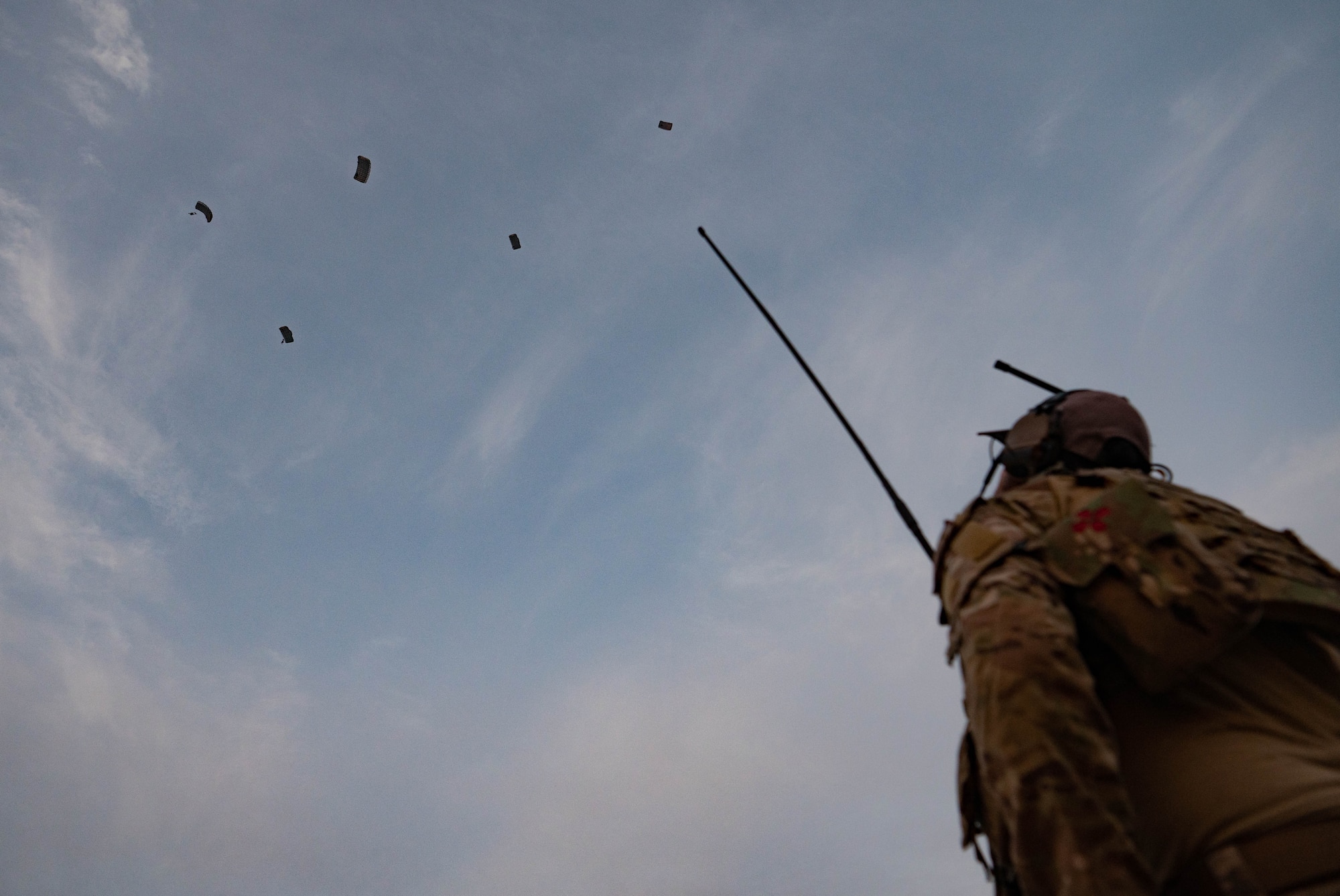 An operator participating in joint training between U.S. and Republic of Korea (ROK) special operations forces, watches as parachutes drop from the sky