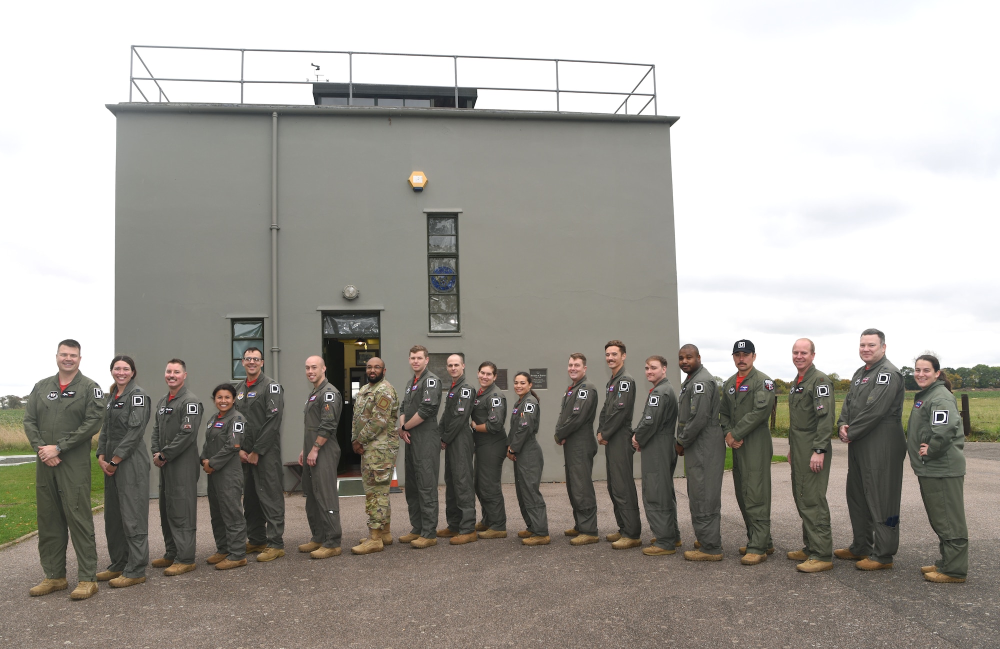 U.S. Air Force pilots and boom operators from the 351st Air Refueling Squadron proudly show off their Square D patches at the 100th Bomb Group Memorial Museum at Thorpe Abbotts, England, Oct. 14, 2022. Thorpe Abbotts was home to the original 351st Bomb Squadron and 100th Bomb Group during World War II. The buzzard patch is the heritage patch and only those who have completed MCT can wear the patch on Fridays. (U.S. Air Force photo by Karen Abeyasekere)