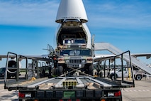 Trailers and Humvees are loaded in to a Boeing 747