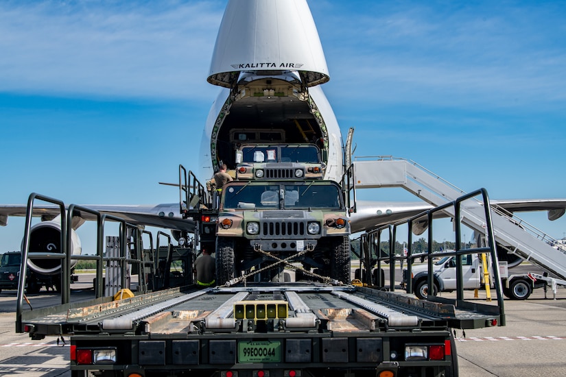 Trailers and Humvees are loaded in to a Boeing 747