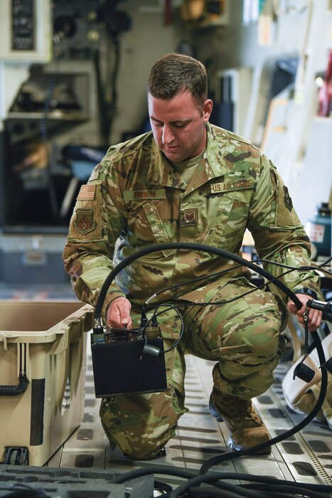 Tech. Sgt. Bradley Fryman, 445th Aircraft Maintenance Squadron communication navigation specialist, sets up communication systems equipment aboard a C-17 Globemaster III aircraft.