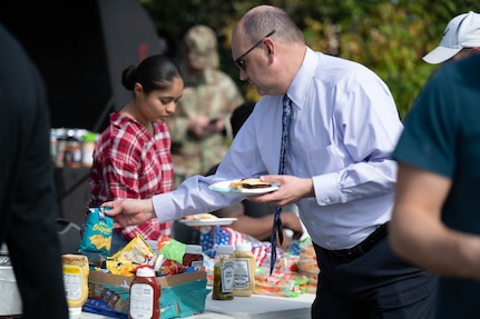 Andy Weaver purchases food from the Brahma's Activity Council's fundraising booth at the Sentinels Celebration, Joint Base Anacostia-Bolling,Washington, D.C., Oct. 12, 2022. The Sentinels Celebration hosted a variety of booths from units on JBAB and mission partners across the National Capital Region. (U.S. Air Force photo by Kristen Wong)