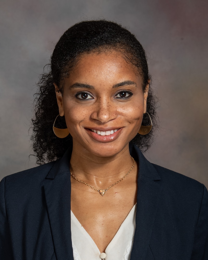 Smiling woman wears a black blazer and white shirt