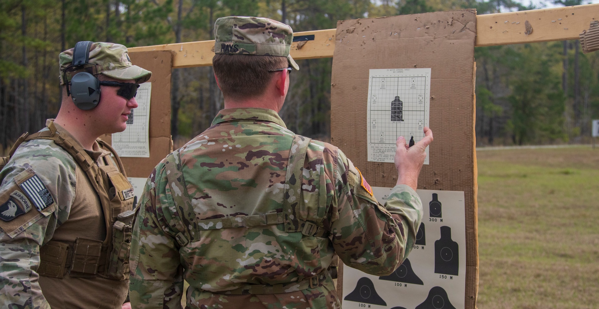 Soldiers look at shot groupings on targets during training.