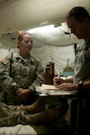 Capt. Melissa Powers, a psychiatric mental health nurse practitioner with the 328th Combat Support Hospital, gives her analysis of a role-playing casualty for her Soldier to annotate during a training exercise at Fort Hunter Liggett, California, July 31, 2015. Powers and 328th CSH are taking part in Operation Caucacus Restore, which engages Soldiers in real world scenarios to prepare them for a deployment. These exercises are adaptive and have the capability to train units as large as 500 service members. (U.S. Army photo by Pvt. Joshua P. Morris/Released)