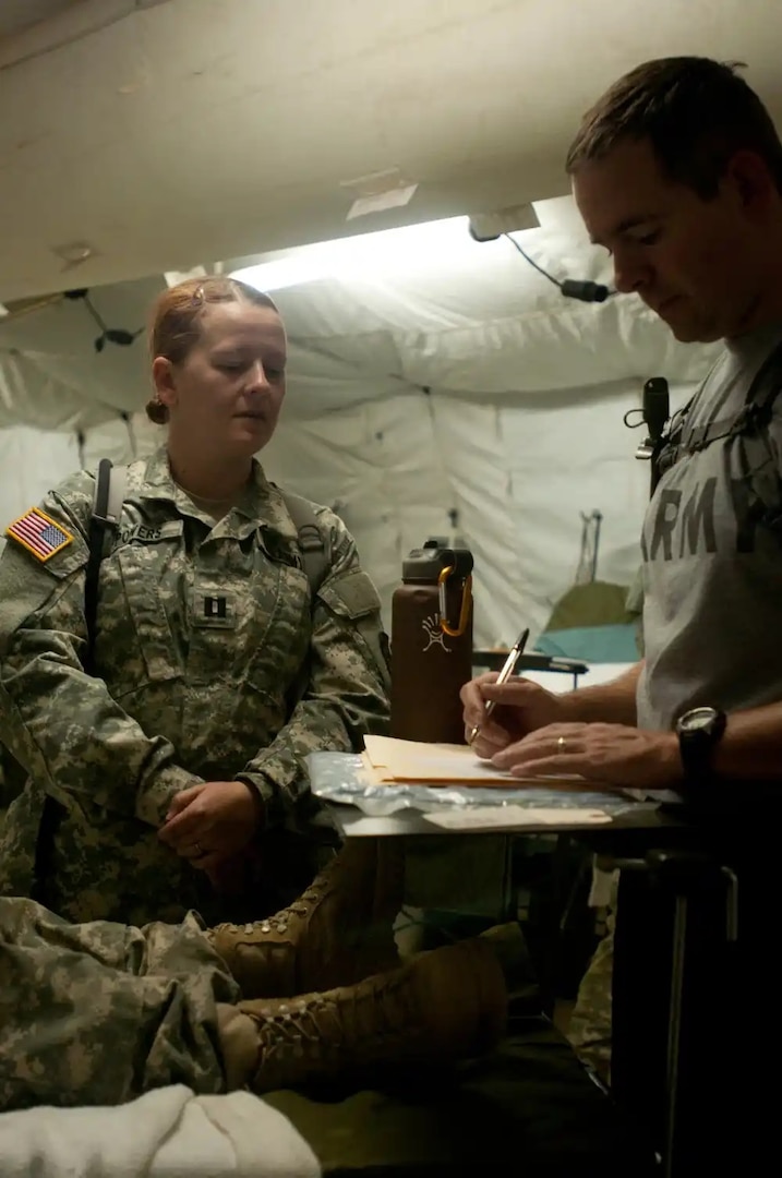Capt. Melissa Powers, a psychiatric mental health nurse practitioner with the 328th Combat Support Hospital, gives her analysis of a role-playing casualty for her Soldier to annotate during a training exercise at Fort Hunter Liggett, California, July 31, 2015. Powers and 328th CSH are taking part in Operation Caucacus Restore, which engages Soldiers in real world scenarios to prepare them for a deployment. These exercises are adaptive and have the capability to train units as large as 500 service members. (U.S. Army photo by Pvt. Joshua P. Morris/Released)