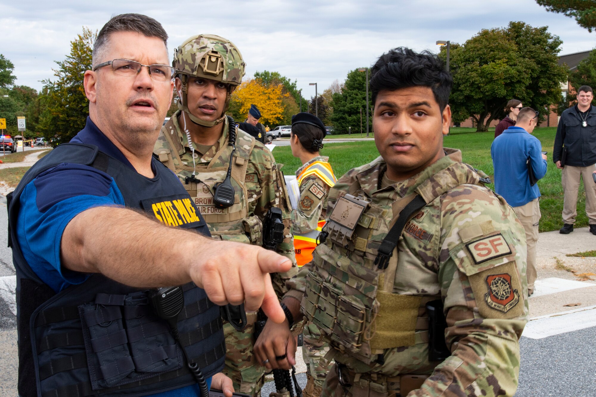 From the left, a member of the Delaware State Police, confers with Master Sgt. Ritchie Brown, 436th Security Forces Squadron flight chief, and Senior Airman Louis Giardino, 436th SFS response force member, during an active shooter exercise held at the Maj. George S. Welch Elementary and Dover Air Base Middle Schools on Dover Air Force Base, Delaware, Oct. 14, 2022. The exercise involved numerous base agencies and community first responders that worked together to neutralize the simulated active shooter. (U.S. Air Force photo by Roland Balik)