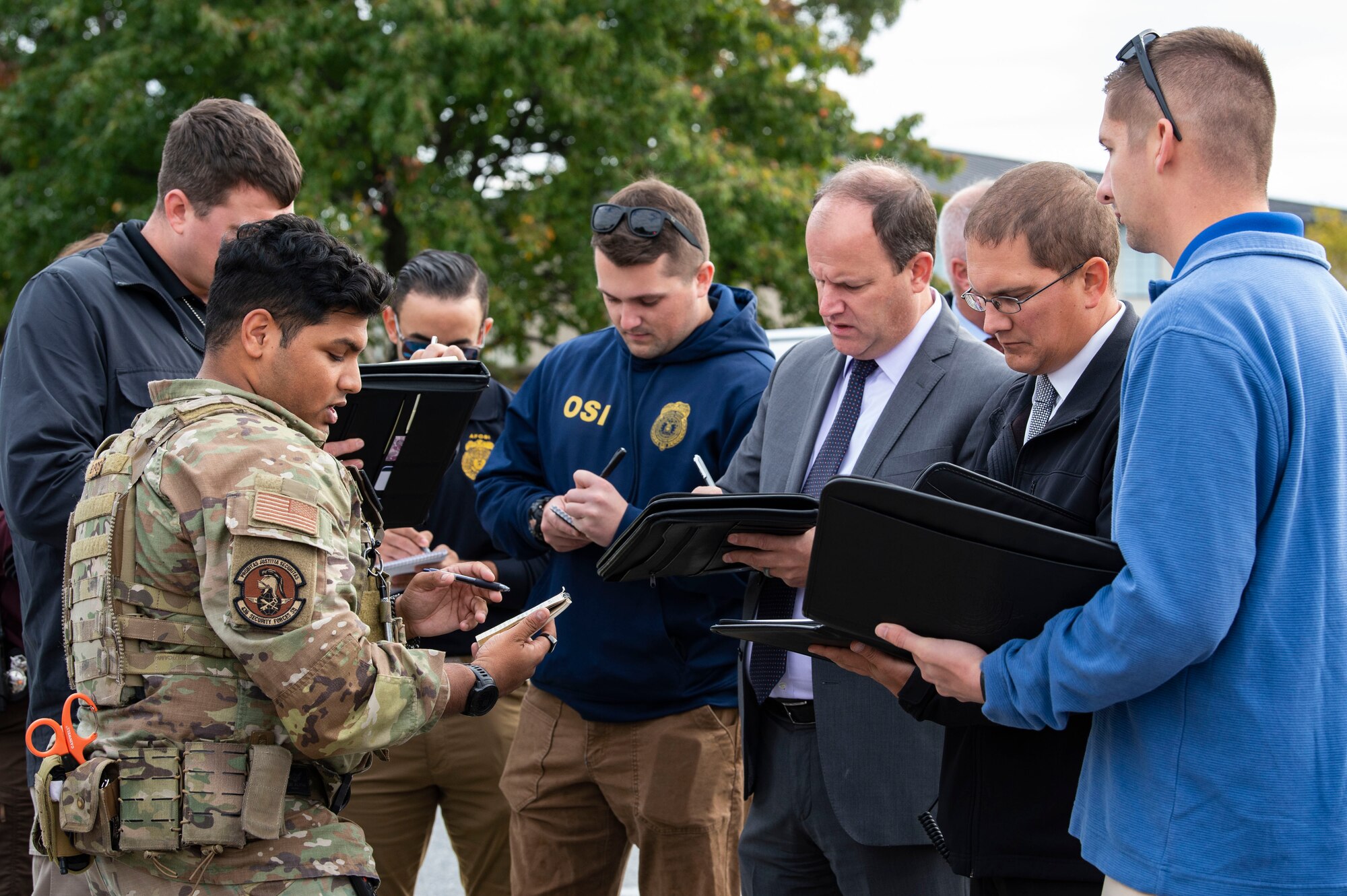 Senior Airman Louis Giardino, left, 436th Security Forces Squadron response force member, briefs representatives from local law enforcement agencies, during an active shooter exercise held at the Maj. George S. Welch Elementary and Dover Air Base Middle Schools on Dover Air Force Base, Delaware, Oct. 14, 2022. The exercise involved numerous base and community first responders that worked together to neutralize the simulated active shooter. (U.S. Air Force photo by Roland Balik)