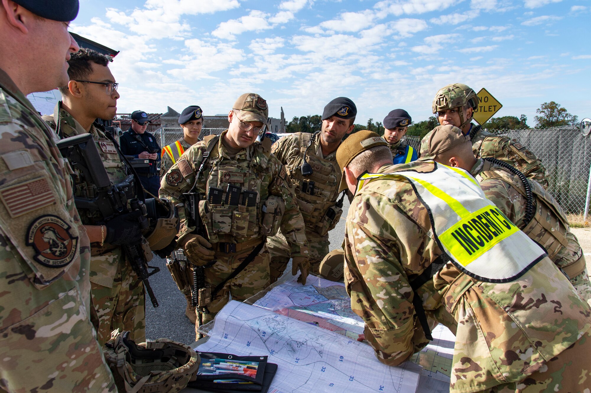 Members of the 436th Security Forces Squadron, gather around Chief Master Sgt. Andrew Kehl, 436th Civil Engineer Squadron fire chief and incident commander for the active shooter exercise held at the Maj. George S. Welch Elementary and Dover Air Base Middle Schools on Dover Air Force Base, Delaware, Oct. 14, 2022. Team Dover first responders worked with community agencies to neutralize the simulated active shooter, secure the scene, rescue hostages, care for the injured and recover casualties. (U.S. Air Force photo by Roland Balik)