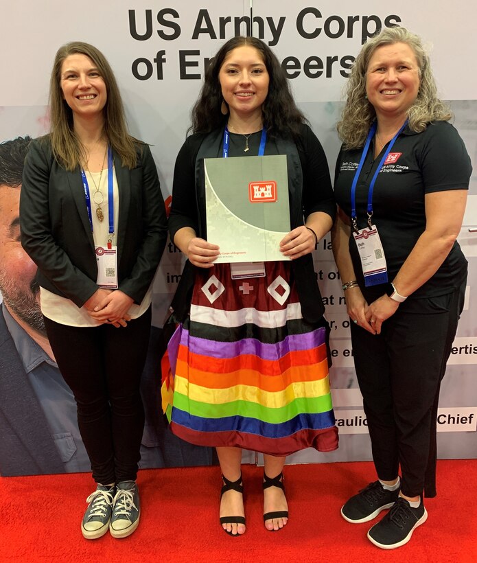 Beth Coffey, Northwestern Division program director, right, and Corina Zhang an Omaha senior resident engineer, left, present a letter of intent to Madison Phelps, a civil engineer major from the South Dakota School of Mines and Technology, during the American Indian Science and Engineering Society National Conference Oct. 7 at the Palm Springs Convention Center in California.