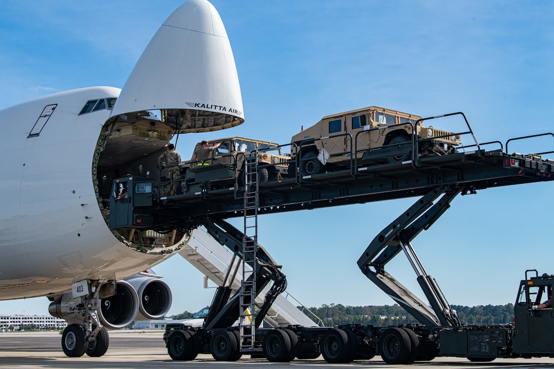 Military vehicles are being loaded onto an aircraft.