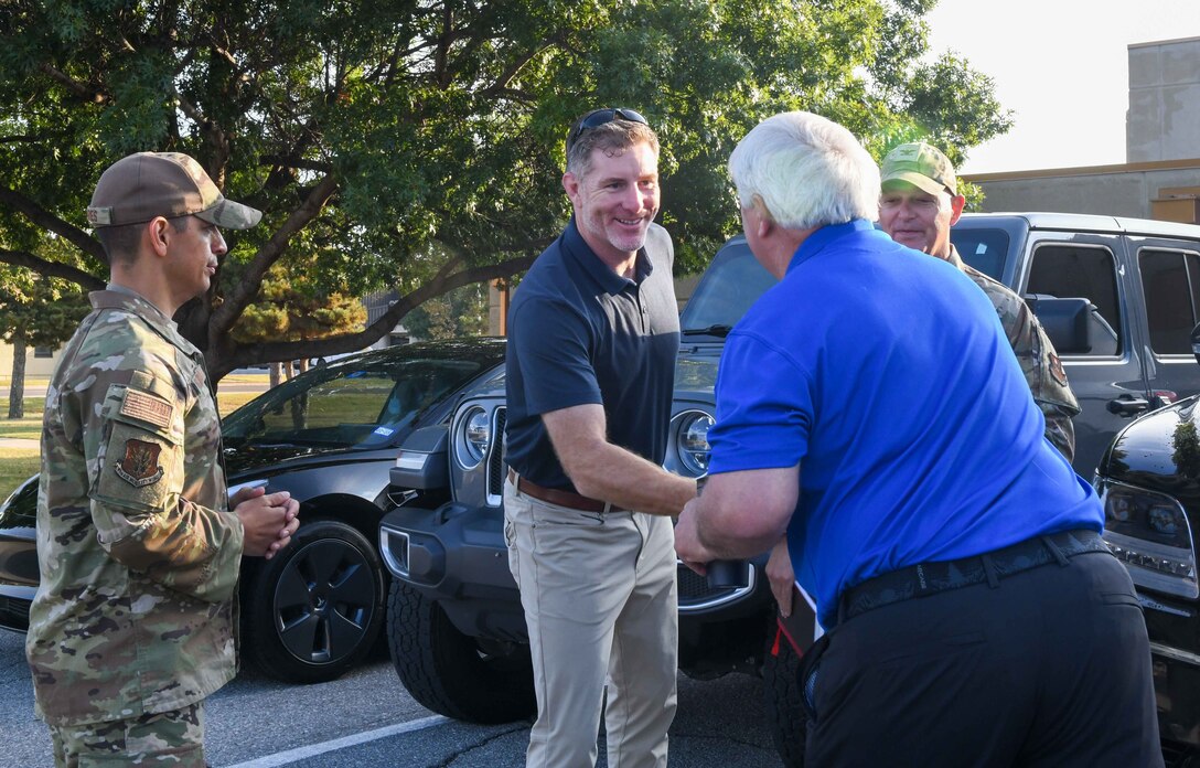 John Nash, Secretary of Military and Veteran Affairs of Oklahoma (center) shakes hands with Robert Cox, a member of the Oklahoma Strategic Military Planning Commission, at Altus Air Force Base, Oklahoma, Oct. 11, 2022. Nash is an Oklahoma native who played basketball at 
the University of Oklahoma before commissioning as an officer with the U.S. Army. (U.S. Air Force photo by Airman 1st Class Kari Degraffenreed)