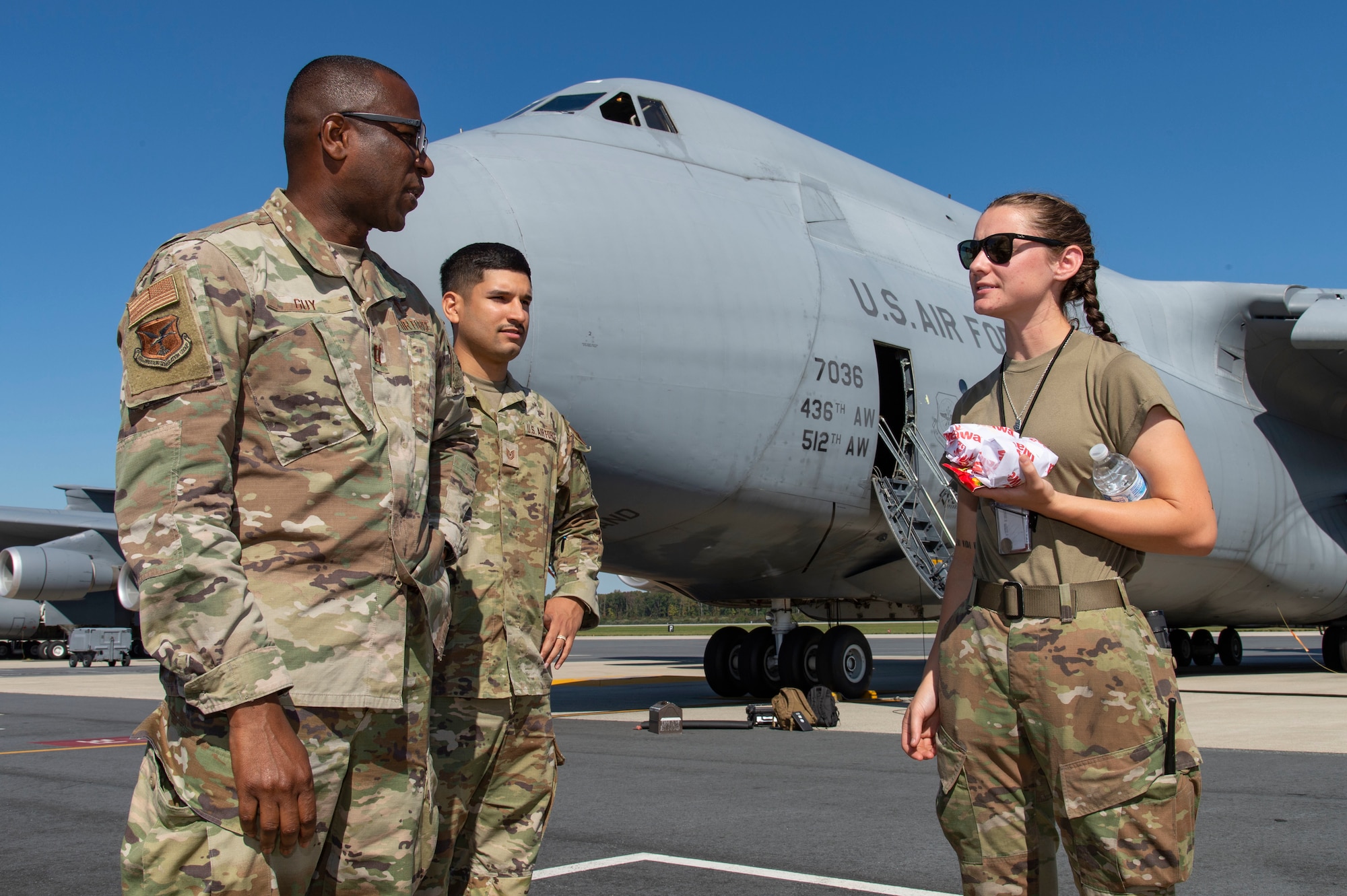 Airman 1st Class Avery Webb, right, 436th Aircraft Maintenance Squadron C-5M Super Galaxy crew chief, chats with Chaplain (Capt.) William Guy, left, 436th Airlift Wing chaplain and Tech. Sgt. Eric Feliciano, center, 512th AW religious affairs airman, during a Friends on the Flight Line visit at Dover Air Force Base, Delaware, Oct. 11, 2022. Webb and other Super Galaxy maintainers paused for a moment to get drinks, sandwiches and snacks from the Holy Roller van as it made numerous stops on the flight line. Guy is the chaplain for the 436th Mission Generation Group which has more than 2,000 military and civilian Airmen. Food items were provided by the United Service Organizations.  (U.S. Air Force photo by Roland Balik)