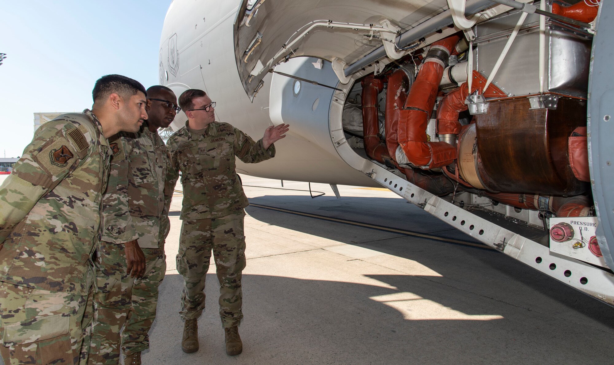 Staff Sgt. Robert Johnson, right, 736th Aircraft Maintenance Squadron C-17 Globemaster III crew chief, explains the function of the left air conditioning pac to Chaplain (Capt.) William Guy, center, 436th Airlift Wing chaplain and Tech. Sgt. Eric Feliciano, left, 512th AW religious affairs airman, during a Friends on the Flight Line visit at Dover Air Force Base, Delaware, Oct. 11, 2022.The Holy Roller van delivered drinks, sandwiches and snacks provided by the United Service Organizations, to aircraft maintainers in various squadrons under the 436th Mission Generation Group. (U.S. Air Force photo by Roland Balik)