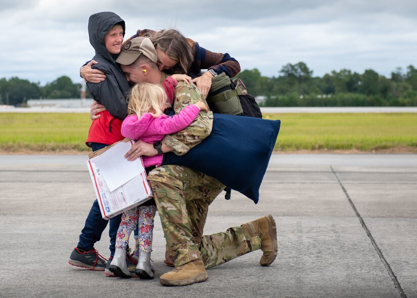 An Airman hugs his family